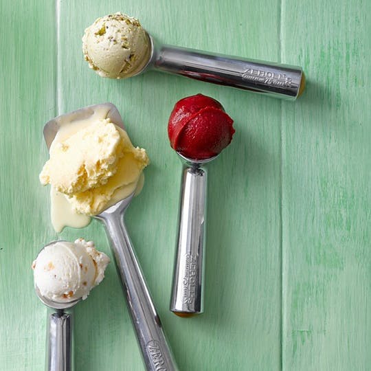 Zeroll ice cream scoops and spades, shown holding scoops of ice cream